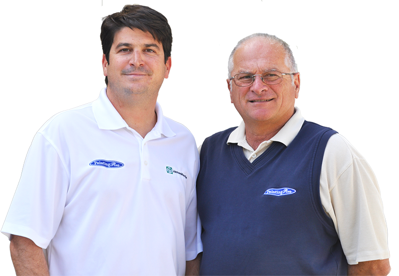 Two men wearing company shirts pose for a photo together; one is in a white polo, the other in a blue vest over a beige shirt, showcasing the team behind exceptional Deck Building and Repairs.